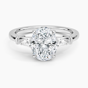 Oval cut lab grown diamond three stone ring with tapered baguette sides in white gold, top view